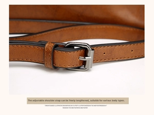 Detail of adjustable brown oil wax leather shoulder strap with dark gunmetal buckle