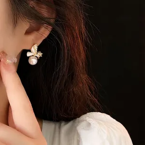 Elegant gold-plated bow earrings with sparkling cubic zirconia and white pearls for women