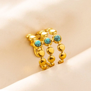 Macro detail of triple-layered gold ring featuring three round turquoise gemstones