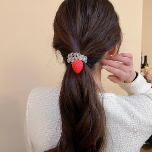 Détail du pendentif fraise rouge sur un élastique à cheveux en spirale gris perle