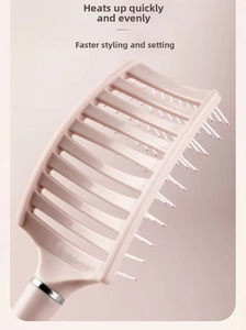 Close-up of curved vented hairbrush with heat-resistant hollow back and pink bristles