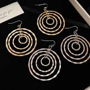 Layered gold and silver textured hoop earrings with multi-circle geometric drop design
