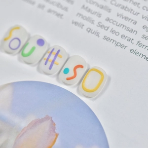 Macro detail of 5D embossed nail art stickers with colorful SOU#SO letter patterns