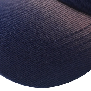Detailed close-up of heavy cotton twill fabric and reinforced stitching on a navy baseball cap