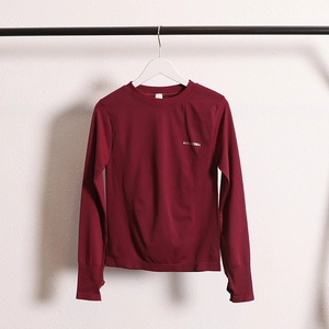 Detail of burgundy long sleeve yoga top featuring thumbholes and breathable knit fabric