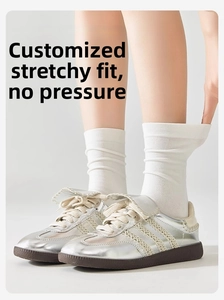 Detailed texture of white ribbed crew socks paired with silver metallic sneakers