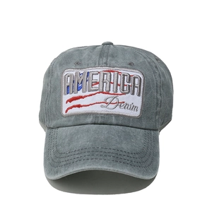 Detailed close-up of embroidered America patch on vintage washed denim baseball cap