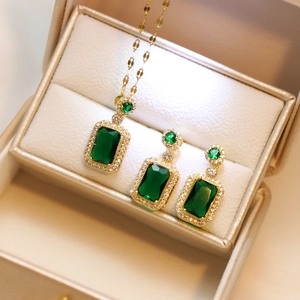 Detailed view of emerald green jewelry set with necklace and earrings in a beige box