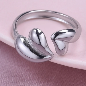 Close-up of a high-polished 304 stainless steel open heart ring on a pink background