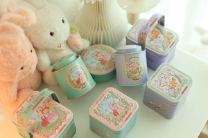 Detailed view of mint and lavender tin containers with cute rabbit illustrations