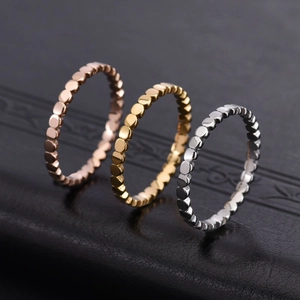 Detailed close-up of three polished 18K gold and silver beaded stackable rings
