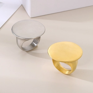Minimalist gold and silver stainless steel oval disc rings with brushed metal texture