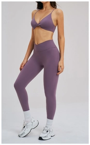 Dettaglio del set da yoga viola con top corto a torsione e leggings a vita alta