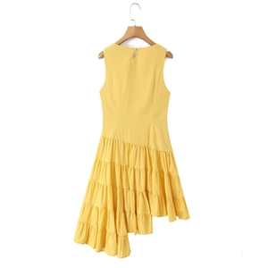 Bright yellow sleeveless dress with an asymmetrical tiered skirt hanging on a hanger