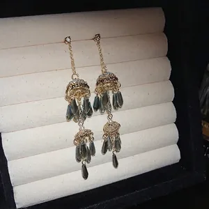 Elegant gold-tone tassel earrings with grey teardrop crystals and white pearls for women