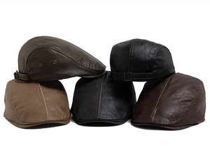Close-up of premium PU leather berets featuring brass eyelets and adjustable metal buckles