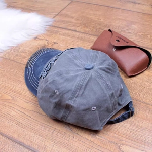 Close-up of vintage washed cotton baseball cap with blue brim on a wooden floor