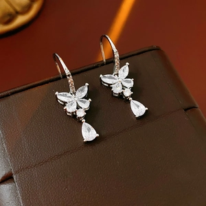 Gros plan de boucles d'oreilles papillon en argent avec zircons sur fond de cuir