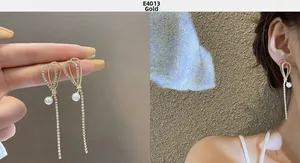 Detail of gold S925 silver needle drop earrings with crystals, pearls and long tassels