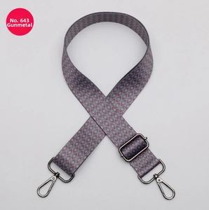 Detail view of ethnic geometric woven bag strap in pink and grey with gunmetal hardware