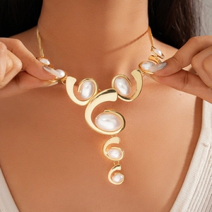 Close-up of gold geometric necklace with white oval pearls in modern wave design