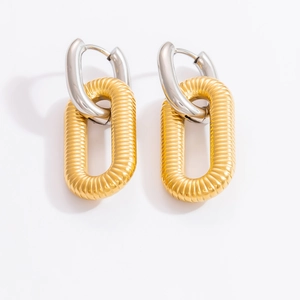 Detail of two-tone geometric chain earrings with silver ring and gold ribbed oval drop