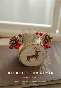 Detailed view of wood Christmas candle holder with pine cones, red berries and reindeer print