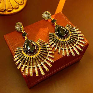 Detail view of vintage baroque drop earrings with black crystals on a leather jewelry box