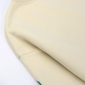 Gros plan du col et de la texture du tissu d'un sweat-shirt à col rond beige