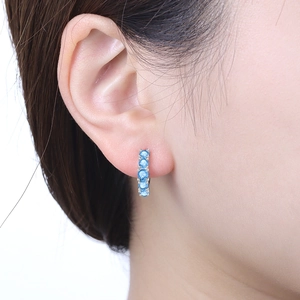 Détail de boucles d'oreilles en argent avec cinq pierres bleu ciel en gros plan