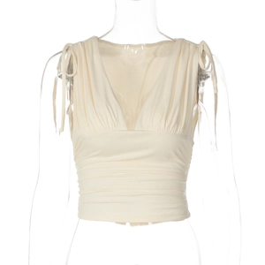 Dettaglio del crop top beige con scollo a V, increspature e spalline annodate