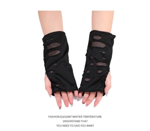 Dettaglio di guanti neri senza dita strappati con fori stile punk per Halloween