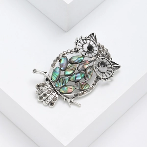 Vintage silver owl brooch featuring abalone shell inlay and sparkling black rhinestones