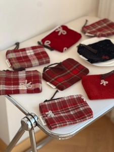 Macro detail of plaid wool coin purses with bow embroidery and simple wish label