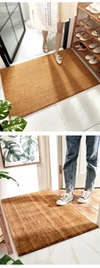 Close-up of brown rectangular natural coco coir doormat with non-slip texture in entryway