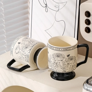 Vintage ceramic rose garden coffee mugs with black handles and floral patterns on white
