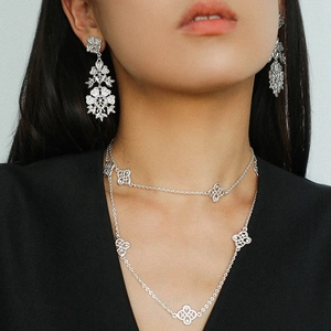 Silver hollow flower earrings and double chain necklace set worn by a model in black suit