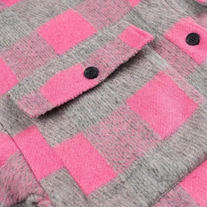 Detailed close-up of pink and grey plaid fabric with a black button and pocket stitching