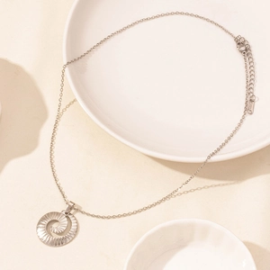 Detailed close-up of a silver stainless steel spiral pendant on a fine link chain