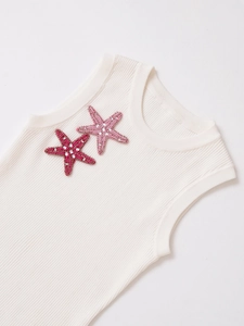 Close-up of ribbed knit texture and handmade pink beaded starfish on white tank top