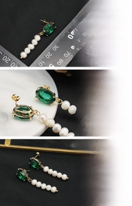 Detailed close-up of 18K gold plated drop earrings with green stone and freshwater pearls