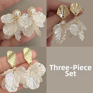 Detailed view of 3-piece set with elegant shell flower earrings and pearl accents
