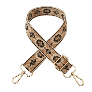 Detail of vintage floral woven bag strap with golden metal hooks and adjustable buckle