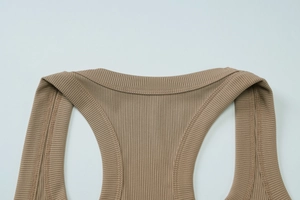 Detailed close-up of ribbed knit texture and double-stitched U-neckline on beige tank top