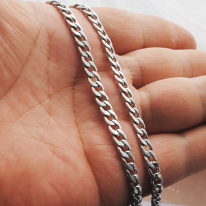 Classic silver stainless steel Cuban link necklace with polished metallic finish held in hand