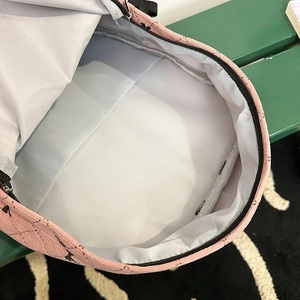 Detail view of pink corduroy backpack interior featuring gray lining and inner pocket