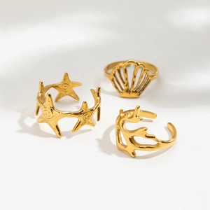 Close-up of ocean-inspired golden rings featuring starfish, shell, and coral motifs