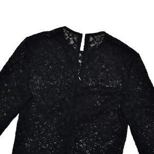 Détail de l'encolure en dentelle noire avec broderies florales ajourées et finitions