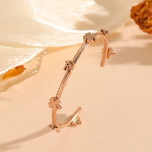 Rose gold open bangle featuring lucky clover and Fu character on warm silk background