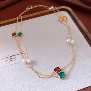 Detail of vintage layered long necklace with colorful square gems and glass pearls